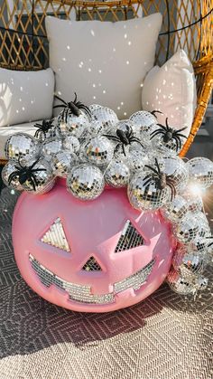 a pink ballon filled with lots of silver balls sitting on top of a table