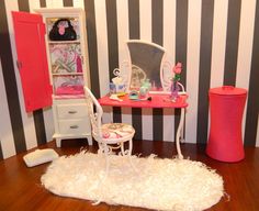 a doll house with furniture and accessories on the floor in front of a striped wall