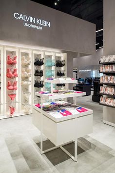 the inside of a clothing store with shoes on display