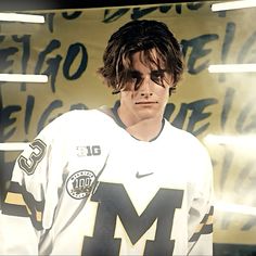 a young man wearing a jersey and sunglasses