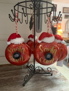 two red donuts with santa claus hats on them hanging from a metal rack in a store