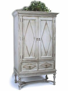 an old white armoire with plants on top