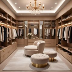 a large walk in closet with a chandelier and two round ottomans on the floor