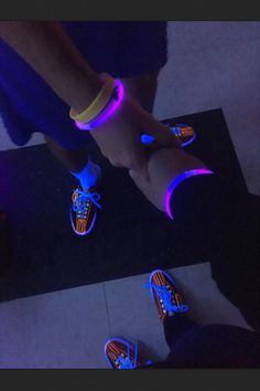 two people standing next to each other with glowing shoes