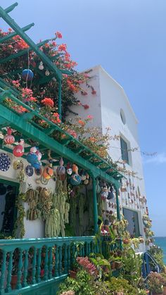 a building with lots of flowers growing on the balcony and balconies above it