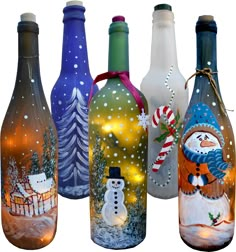 four bottles with snowmen and christmas decorations painted on them, all decorated in different colors