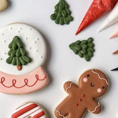 decorated christmas cookies and other holiday treats on a white surface with candy canes, carrots, trees, and snowflakes