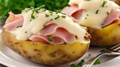 two stuffed potatoes with ham and cheese on top, garnished with parsley