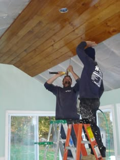 two men working on a wood ceiling