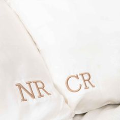 two white pillows with embroidered initials on them