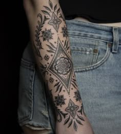 a woman's arm with a tattoo on it that has flowers in the middle