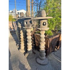 two sculptures made out of rocks with faces on them