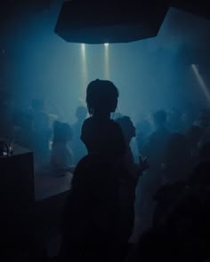 the silhouette of a person standing in front of a crowd at a club or nightclub