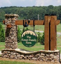 a sign for the king's family farm in front of a stone wall and wooden gate