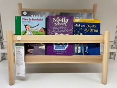 a wooden shelf with books on it and two shelves for children's books to read