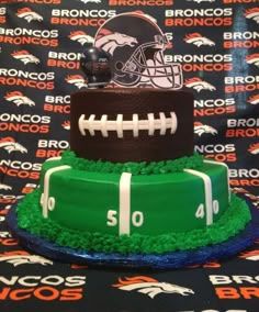 a three tiered cake with football and helmet on top