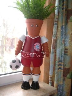 a planter with a soccer player on top of a shelf next to a window