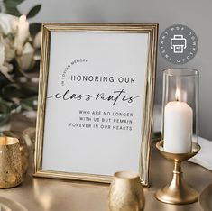 a white and gold framed sign on a table next to candles, vases and flowers