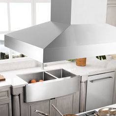 a modern kitchen with stainless steel appliances and white counter tops