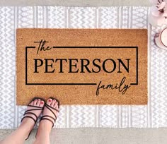 a person standing in front of a door mat that says the personal family on it