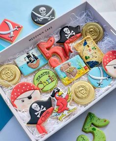 decorated cookies in a white box with pirate themed cookie toppers on the bottom and side