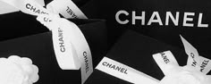 black and white photograph of chanel logo with hand holding it up to the camera