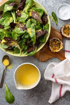 a green salad in a bowl with dressing next to it