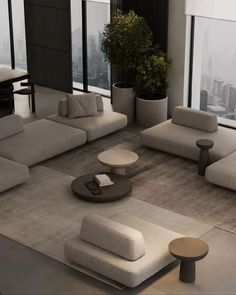 a living room filled with lots of couches and tables in front of large windows