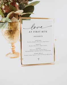 a table setting with flowers and a sign that says love at first bite desserts