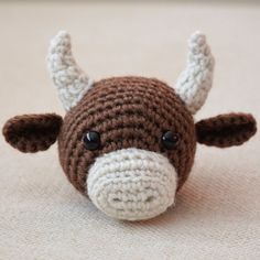 a crocheted brown and white cow with horns