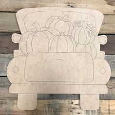 a cutout of pumpkins and squash in a basket on a wooden background with planks