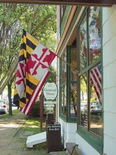 the flags are hanging outside of the storefront window on the side of the building