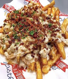 a pile of food sitting on top of a plate next to french fries and ketchup