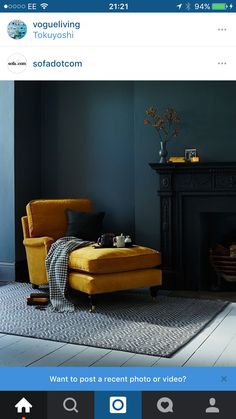 a living room with blue walls and a yellow chair in front of a fire place