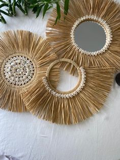 three circular mirrors made out of straw on top of a table