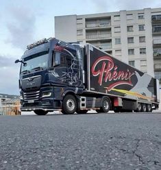 a large semi truck parked in front of a building