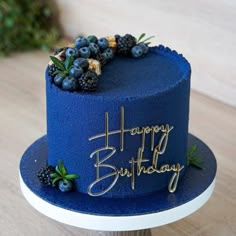 a blue birthday cake sitting on top of a wooden table