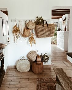 several baskets hanging on the wall in a room with tile flooring and wooden stairs