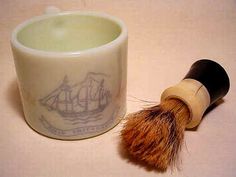 a shaving brush sitting next to a cup