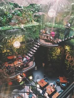 people sitting at tables in the middle of a garden