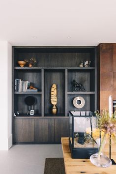 a wooden table sitting in front of a bookshelf filled with lots of shelves