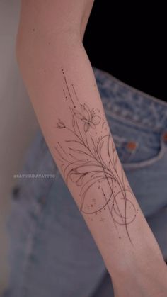 a woman's arm with a tattoo on it that has flowers in the middle