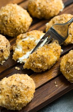 a close up of some food on a wooden table with a fork in it's mouth