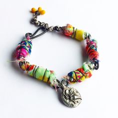 a multicolored bracelet with a tree charm