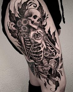 a woman's thigh with a skeleton and flowers on it