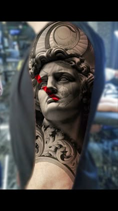 a man's arm with a tattoo on it and an image of a statue in the background