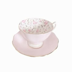 a cup and saucer sitting on top of a pink saucer with floral designs