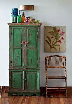 a green cabinet sitting next to a wooden chair