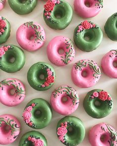 there are many donuts with pink and green frosting