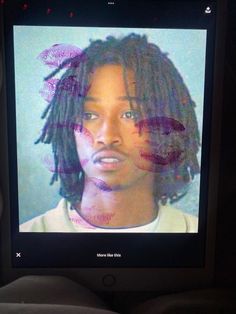 a man with dreadlocks on his face is shown on a television screen in the dark